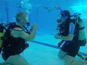 Try diver in swimming pool with instructor